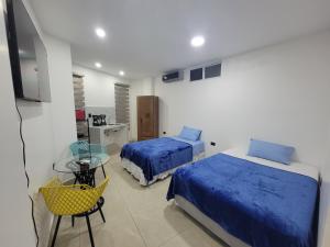 a bedroom with two beds and a table and a desk at Andrea Suite 3 in San Cristobal