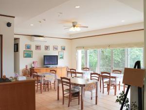 une salle à manger avec des tables, des chaises et une télévision dans l'établissement Pine Shima Resort Coral Fish - Vacation STAY 37439v, à Ibaruma