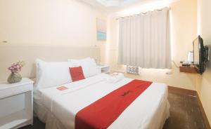 Postel nebo postele na pokoji v ubytování RedDoorz Premium at THE GRAND PENINSULA SUITES