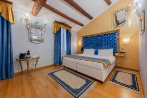 a bedroom with a bed with blue curtains and a table at Ca Dell'Arte in Venice