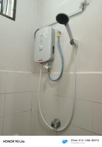 a shower in a bathroom with a hand dryer on a wall at IRDINA HOMESTAY forMuslims - Changlun in Changlun