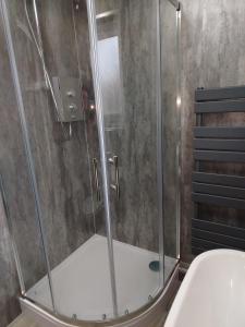 a shower with a glass door in a bathroom at 198 Headwards Retreat in Hemsby +20 photos