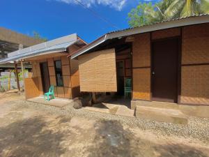 a house with a green chair in front of it at Monera's Native Cabin in San Juan +20 photos