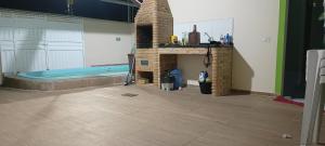 a living room with a fireplace and a bath tub at Casa com piscina e churrasqueira para família in Marechal Deodoro +14 photos