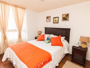 a bedroom with a large bed with orange pillows at Sweet Stay Chile in Santiago
