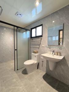 a bathroom with a toilet and a sink at 翹班旅行民宿 in Magong