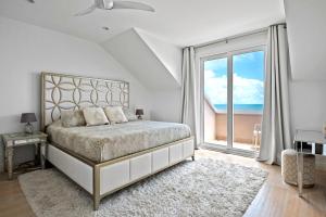 a bedroom with a large bed and a large window at White House - Exclusive Luxury Beachfront Villa - Private White Sand Beach in Nassau +35 photos