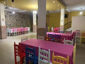 a large room with pink tables and chairs at Hotel El Encuentro in Tochimpa
