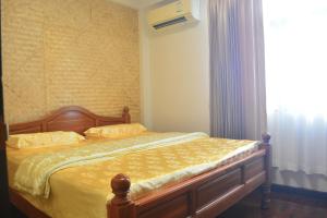 a bedroom with a bed with yellow sheets and a window at Sweety Secret Guesthouse in Ban Tambon Bang Khae