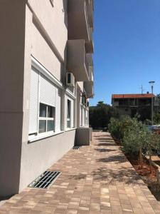 un edificio con una acera de ladrillo junto a un edificio en Mikulić Apartments, en Zadar