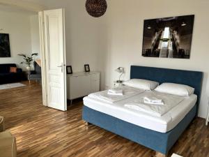 sypialnia z łóżkiem z niebieskim zagłówkiem w obiekcie Casa Nostra - Sonnige Wohnung direkt am Augarten w Wiedniu