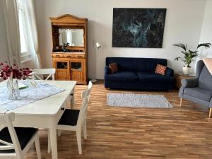 salon ze stołem i niebieską kanapą w obiekcie Casa Nostra - Sonnige Wohnung direkt am Augarten w Wiedniu +5 zdjęć
