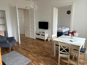 salon ze stołem jadalnym i telewizorem w obiekcie Casa Nostra - Sonnige Wohnung direkt am Augarten w Wiedniu