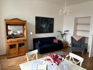 salon z niebieską kanapą i stołem w obiekcie Casa Nostra - Sonnige Wohnung direkt am Augarten w Wiedniu