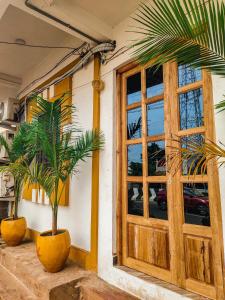 une porte menant à un bâtiment avec deux palmiers devant dans l'établissement La Dreamy Beach Residency, à Pondichéry