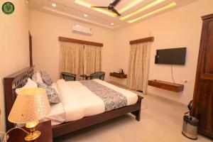 Un dormitorio con una cama y un televisor de pantalla plana. en Padam Heritage, en Jodhpur