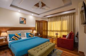 a bedroom with a blue bed and a red couch at Perfectstayz Value Vista 5 min walk to Mall road in Mussoorie