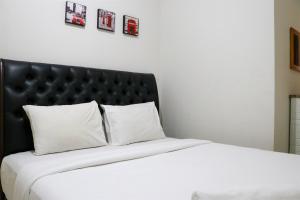 Postel nebo postele na pokoji v ubytování Tranquil Designed and Homey 2BR at Springlake Summarecon Bekasi Apartment By Travelio + 18 fotografií