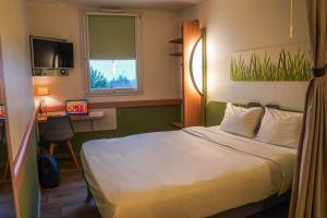 Ένα ή περισσότερα κρεβάτια σε δωμάτιο στο Ibis Budget Bayeux +30 φωτογραφίες