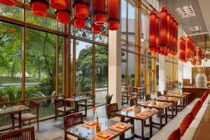 un ristorante con tavoli, sedie e ampie finestre di Angsana Lang Co a Lăng Cô Altre 37 foto
