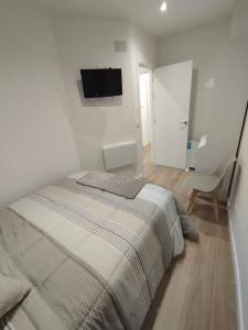a bedroom with a bed and a tv on the wall at Ponte do Burgo Primero in Pontevedra +7 photos