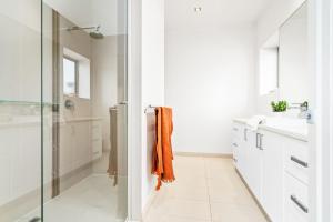 a bathroom with white cabinets and an orange towel at Mariner House in Port Fairy +22 photos