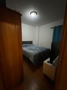 a small bedroom with a bed and a television at Sossego in paradise in Ponta Delgada +4 photos