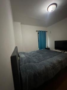 a bedroom with a bed and a blue curtain at Sossego in paradise in Ponta Delgada