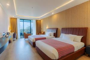 una camera d'albergo con due letti e una scrivania di Lake View Resort a Pokhara Altre 37 foto