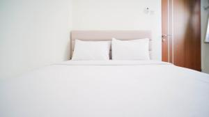 Ένα ή περισσότερα κρεβάτια σε δωμάτιο στο Cozy Living and Tidy 2BR at Puncak Dharmahusada Apartment By Travelio +20 φωτογραφίες