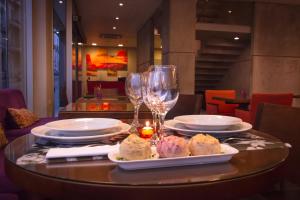 a table with plates of food and glasses of wine at AXSUR Design Hotel in Montevideo