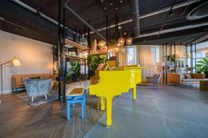a yellow piano in the middle of a room at Vienna House Easy by Wyndham Amsterdam Airport Schiphol in Hoofddorp