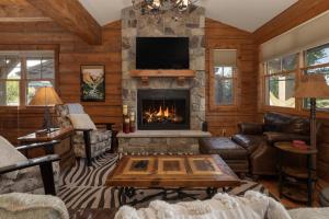 a living room with a fireplace and a tv at 19th Hole cabin in Granby