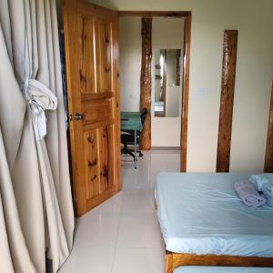a bedroom with a bed and a door and a table at Boone Homestay in Sagada +4 photos