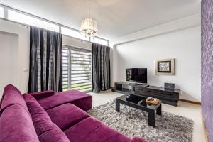 a living room with a purple couch and a tv at Serra e Mar Refuge in Sesimbra - Family Friendly home near the Arrábida Beachs in Sesimbra