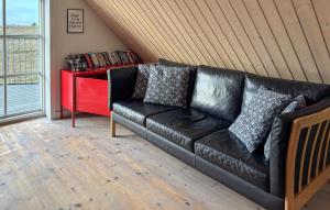 a black leather couch in a room with a red table at Holiday Home Syrenvej Skjern Iii in Skjern