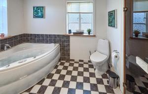 a bathroom with a tub and a toilet at Holiday Home Syrenvej Skjern Iii in Skjern +14 photos