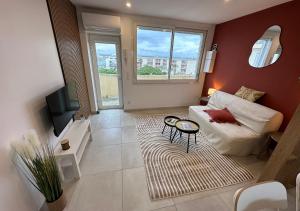 a living room with a couch and a tv at Le Studio Terracotta - Central & Lumineux in Palavas-les-Flots
