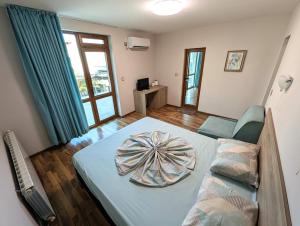 a room with a bed and a couch and a window at Guest house Sineva in Primorsko