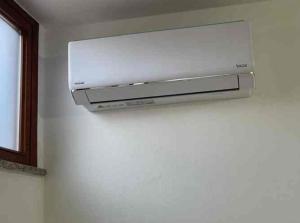 a white microwave hanging on a white wall at Comfort Apartment in Assemini