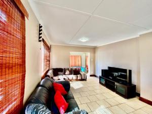 a living room with a couch and a flat screen tv at Seaside Haven in Pearly Beach