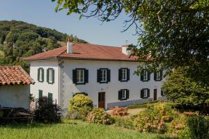 a large white house with a red roof at Maison Gamboia, chambres d'hôtes au calme avec jardin in Hasparren
