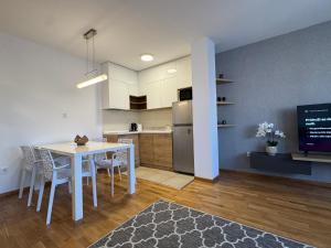 a kitchen and dining room with a white table and chairs at NOVI SAD CITY CENTER in Novi Sad