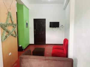 a living room with a couch and a tv at Omolade Guest Place in Baguio