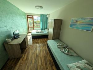 a room with a bedroom with a bed and a desk at Guest house Sineva in Primorsko +14 photos
