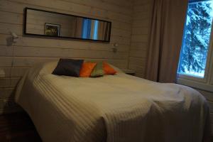 a bedroom with a large bed with a window at Aihki Pine Cottage, Iso-Syöte in Syöte