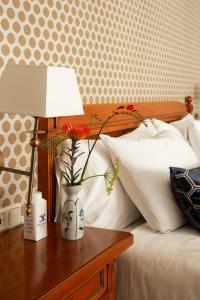 een bed met een tafel met een lamp en bloemen erop bij Dikker & Thijs Hotel in Amsterdam