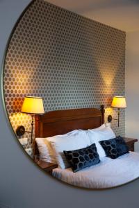 een slaapkamer met een bed met 2 lampen en een spiegel bij Dikker & Thijs Hotel in Amsterdam