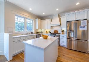 eine Küche mit weißen Schränken und einem Edelstahlkühlschrank in der Unterkunft American Foursquare Craftsman Spacious and Light 4285 in Hood River