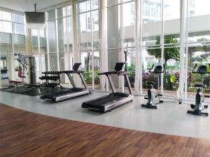 a gym with treadmills and ellipticals in a building at Strategic and Restful 1BR at Casa De Parco Apartment By Travelio in Tangerang